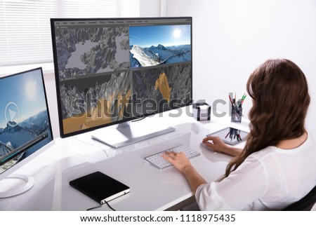 Rear View Of A Woman Working On 3D Landscape On Computer In Office