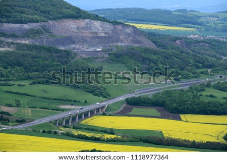Highway bridge above the oilseed fields by the mined hill