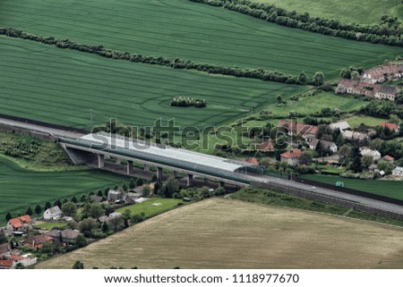 Covered highway bridge between villages houses and green fields