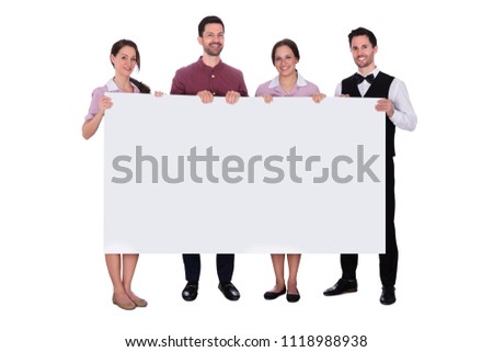 Portrait Of Smiling Staff Holding Blank White Billboard
