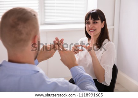 Close-up Of Man Learning Sign Language From Young Woman