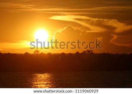 Sunset in the Zambezi River, Zambia and Zimbawe border, with some clouds around taken from the water, Africa Royalty-Free Stock Photo #1119060929