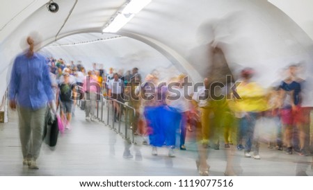 Blurred crowd of people moving on the transition between underground stations