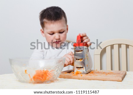the child is preparing a salad in the kitchen on white background