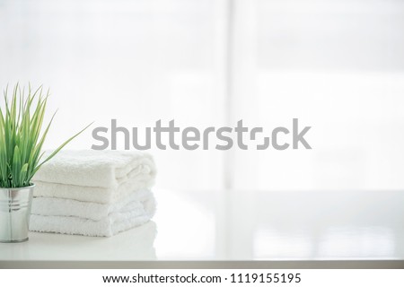 Towels and houseplant on white table with copy space. For product display montage. Royalty-Free Stock Photo #1119155195