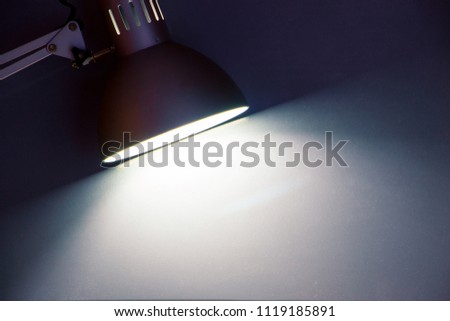 Close up office desk lamp night light in dark background Vintage style picture.