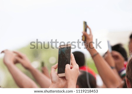 Hands of fans taking show smartphones