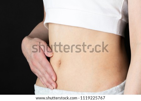 Young woman touching her belly.