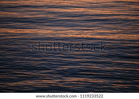 Beautiful golden sunset lighting reflects from Adriatic Sea water surface in the evening.Natural beauty background.