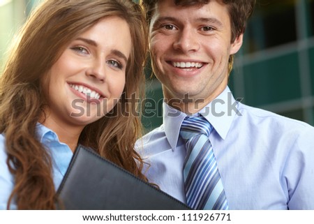 Close portrait of a smiling attractive business young couple working together, outdoor shoot