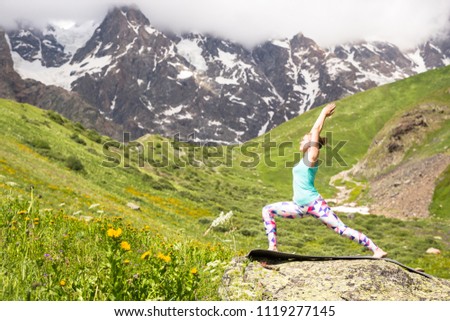 Young woman doing yoga in beautiful mountains. Nice view.