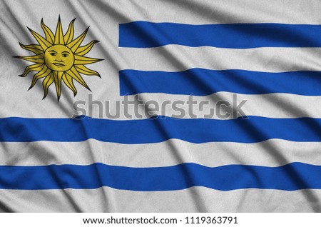 Uruguay flag  is depicted on a sports cloth fabric with many folds. Sport team banner