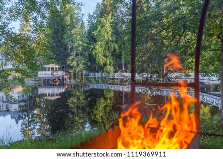 White bridges over water connecting islands through a flame of fire are reflected in water
