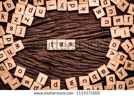 Tax word written cube on wooden background. Vintage concept.