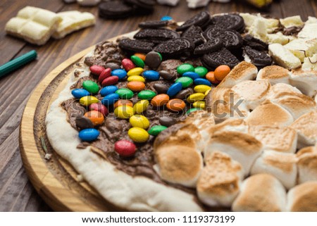 sweet pizza with chocolate and marshmallow on wooden background
