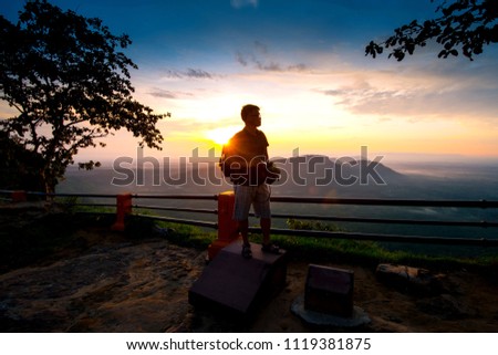 Asian male backpack in nature during sunset   Relax time on holiday concept travel at Pha mor i dang,Sisaket province,Thailand,ASIA.