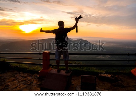 Asian male backpack in nature during sunset   Relax time on holiday concept travel at Pha mor i dang,Sisaket province,Thailand,ASIA.