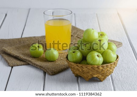 Indian gooseberry in Wicker basket and juice, Sackcloth on white wooden table