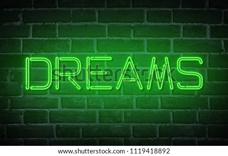 Green neon text Dreams on brick wall background. Dark tones vintage image