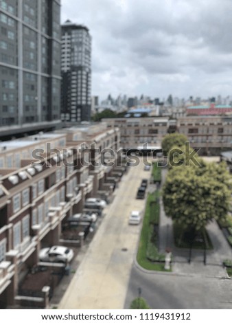 Blur picture of cityscape. Blur picture of townhouse, road and small park surrounding with high buildings and cityscape view of a big city in the background.