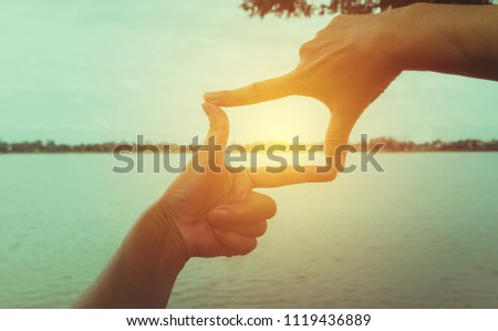 Close up of hands making frame gesture. Close up of woman hands making frame gesture with sunset.