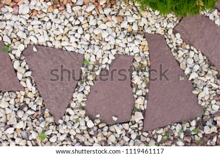 Modern decoration of the garden with decorative bushes and gravel. Table