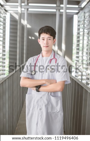 Doctor with stethoscope around his neck looking at the camera
