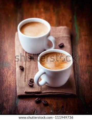 Two cups of espresso on rustic wooden table. Symbolic image. Coffee and coffee beans. Rustic wooden background. Close up. Royalty-Free Stock Photo #111949736