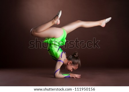 small girl gymnast stand on hands