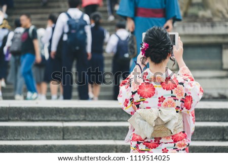 Closeup Young japanese woman wearing kimono taking photo with tablet on shopping street in Kyoto, Japan
