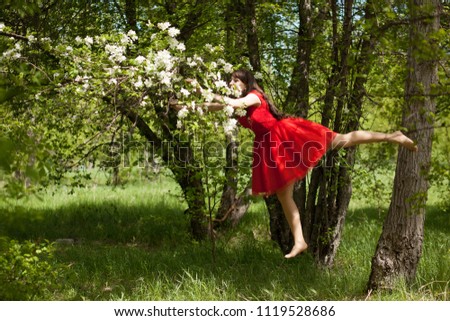 fairy flower. beautiful girl in a red dress among the flowers. photo for your design