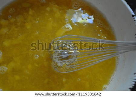 Metal kitchen whisk in a fruit apricot broth, a kampot from fresh apricot for fruit jelly