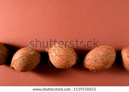 Several whole coconuts on brown surface. Top view