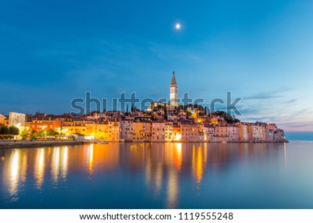 Colorful sunset of Rovinj town, Croatian fishing port on the west coast of the Istrian peninsula. Colorful evening seascape of Adriatic Sea. Traveling concept.