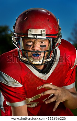 Young American football player in the ready stance. Royalty-Free Stock Photo #111956225