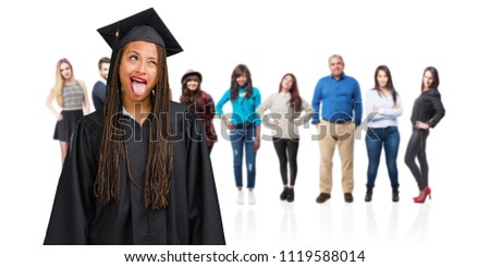 Young graduated black woman wearing braids expression of confidence and emotion, fun and friendly, showing tongue as a sign of play or fun