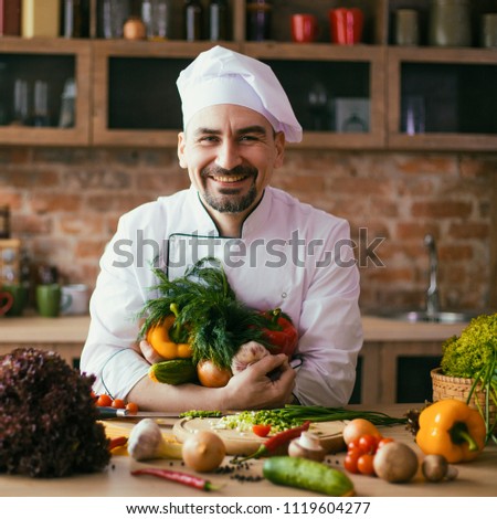 young chef in the kitchen, on the table fresh vegetables for cooking