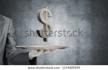 Cropped image of waiter's hand in glove presenting stone dollar symbol on metal tray with gray wall on background. 3D rendering.