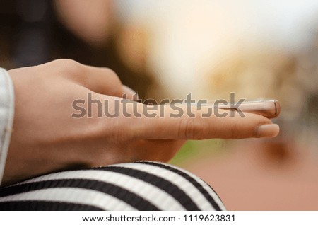 Woman sitting on the bench with mobile phone nature sun city on blur background