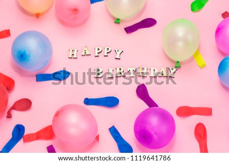 wooden letters forming happy birthday and colorful ballons  on pink background , holiday concept