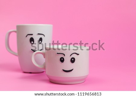 Two white ceramic mugs with painted funny faces. Relationships, Couples, Love.