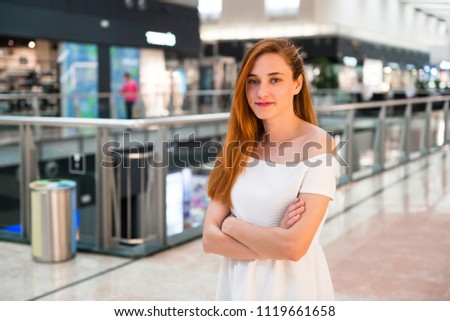 Young redhead pretty girl in a shopping center