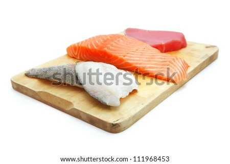 fresh raw sole , salmon , and red tuna fish  pieces on wooden plate isolated on white background