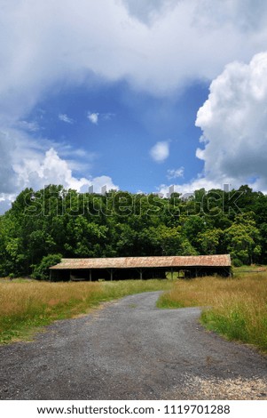 A green barn in a field in a rural area of Virginia.