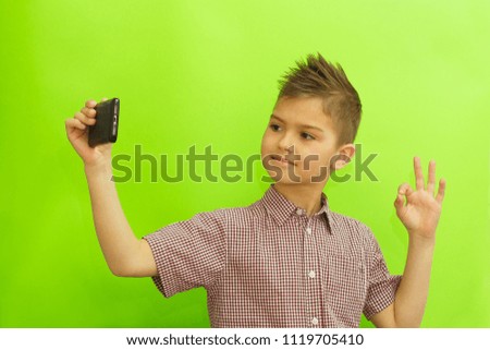 Schoolboy make selfie on color background. Back to school concept background with copy space.