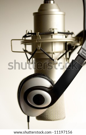 Studio Microphone with headphones hanging on it.