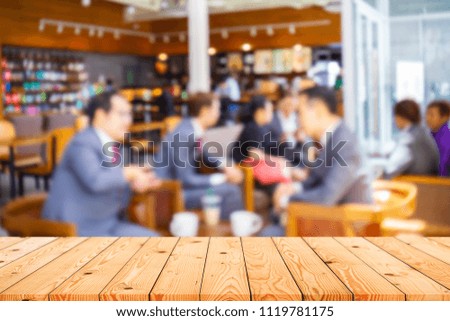 Empty top of wooden table with blurred interior in coffee cafe background at day time