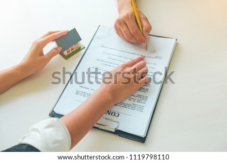 Women Real Estate Agent showing where to sign on document for buy house contract. Home loan contract, Real estate Concept