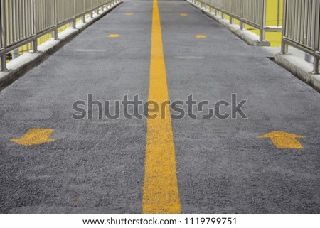 Walkway and arrow symbol, overpass and yellow traffic sign