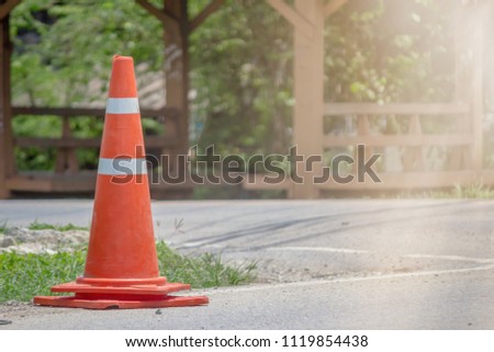 soft Focus,An orange cone is placed on the roadside to warn motorists and prevent accidents that occur when it reaches the point of installation and where the work is being done on the road surface.